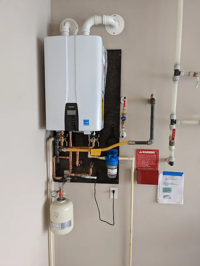 Professional plumber installing copper piping in a Suffield home